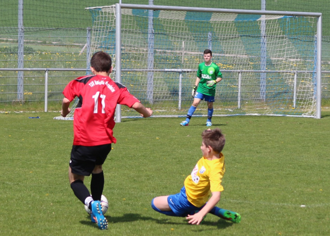 Dominic Bock versucht seinen Gegenspieler mit einer Grätsche zu stoppen