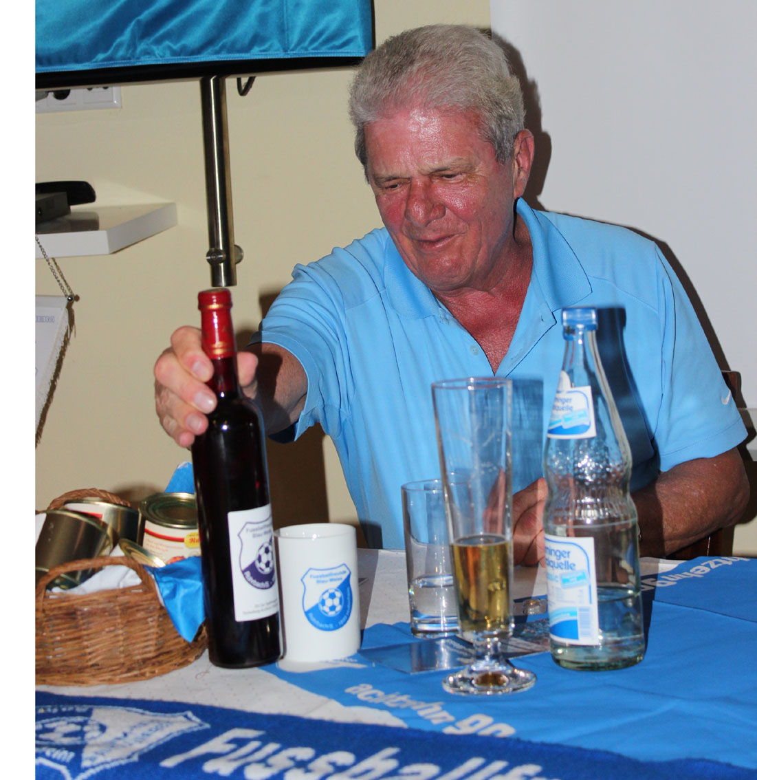 Dietmar Hopp blickt erfreut auf die Fanclub-Geschenke