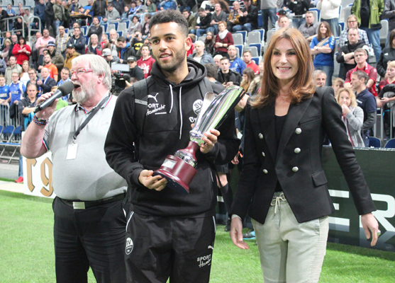 Sandhausens Andrew Wooten nimmt von Marnie Eichhorn, vom Hauptsponsor Harder13, den dritten Siegerpokal entgegen
