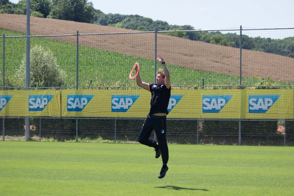 Mit einem Sprung schnappt sich der TSG-Coach den heranfliegenden Wurfring ...