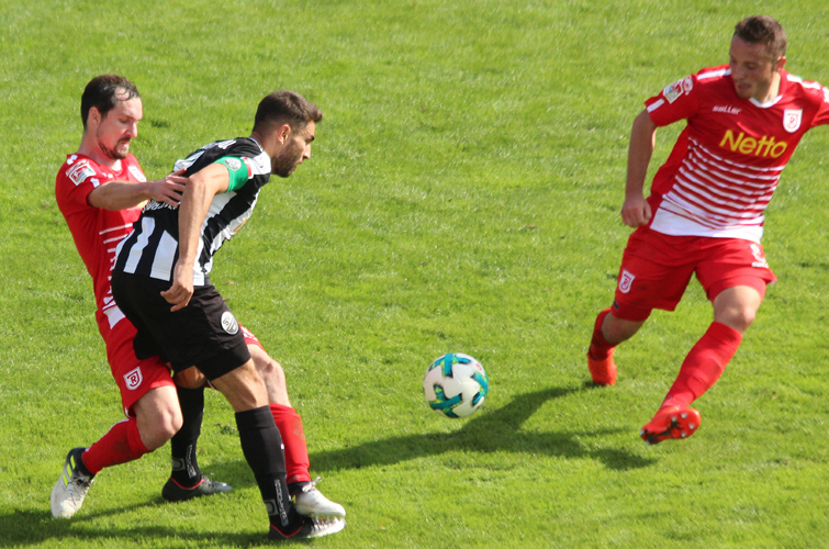 Daghfous versucht sich gegen zwei Regensburger Gegenspieler durchzusetzen