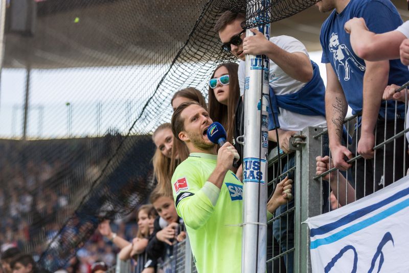 Baumann feiert mit dem Mikro in der Fankurve