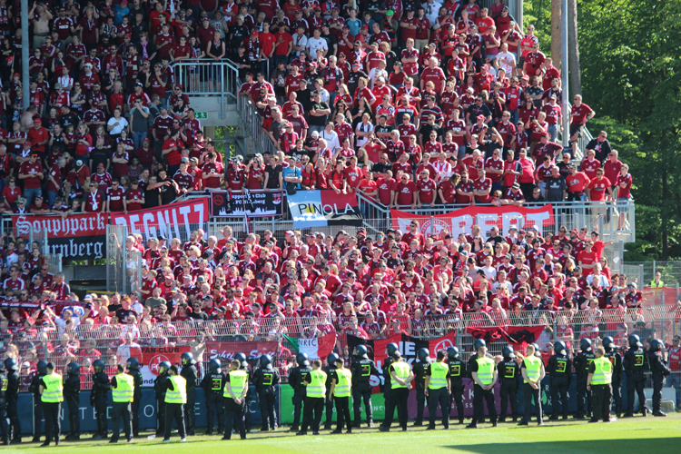 Sicherheitskräfte versuchen die Nürnberg Fans vor dem Platzsturm zu hindern