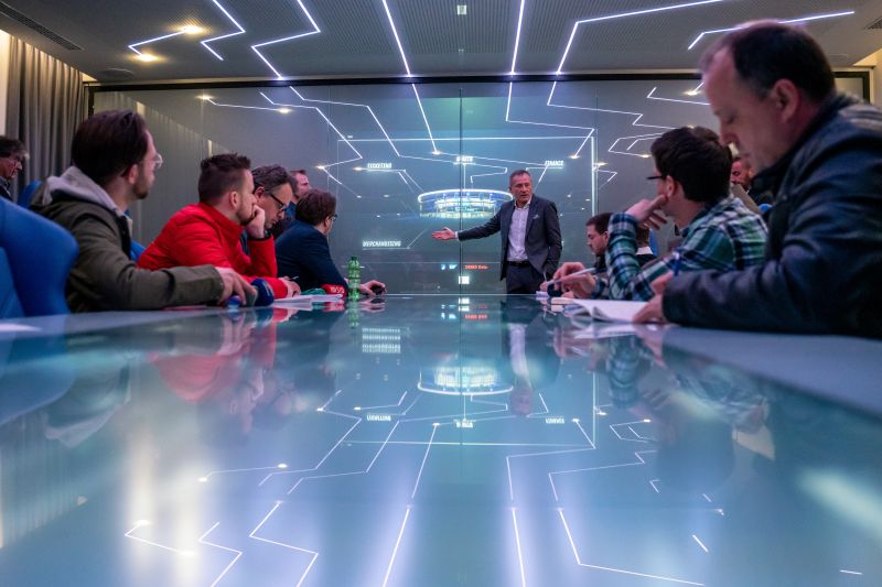 Medienvertreter an den individuell zu bedienenden Touchscreen Glastischen