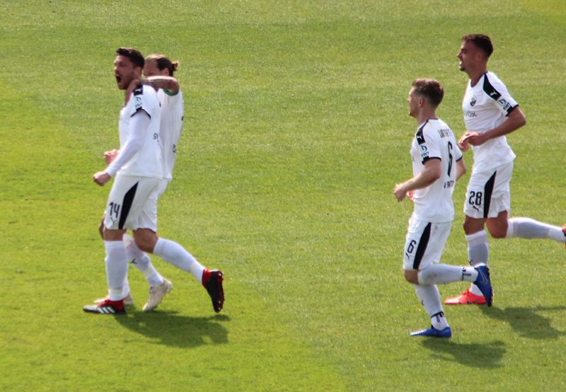 Die Mitspieler feiern Kister nach dessen Kopfballtor zur 1:0-Führung