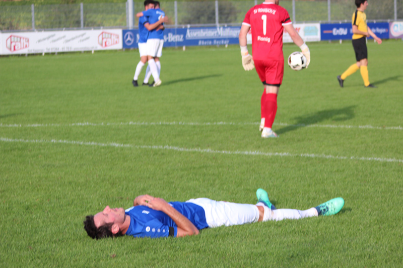 Ein abgekämpfter Markus Brecht, während seine Kameraden im Hintergrund den Sieg feiern