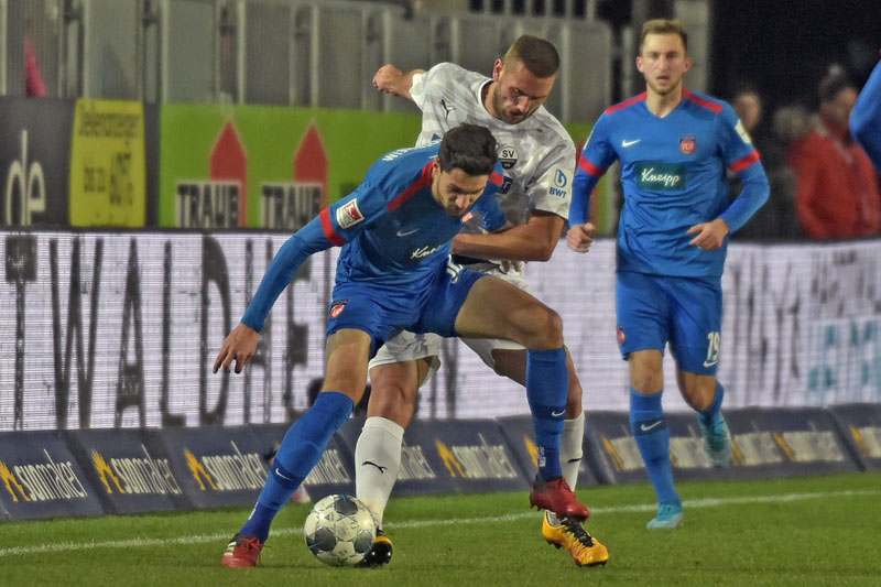 Zweikampf zwischen dem Heidenheimer Tim Kleindienst (vorne) und dem Sandhäuser Ivan Paurevic. Im Hintergrund in der Beobachterrolle Jonas Föhrenbach.