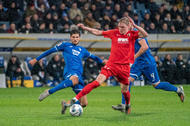 Hoffenheims Grillitsch versucht per Grätsche Augsburgs Fredrik Jensen zu stoppen