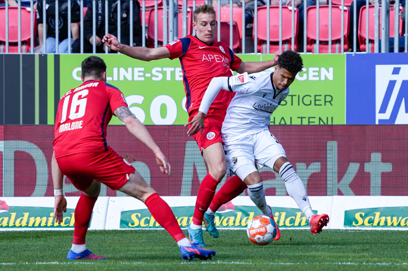 Sandhausens Okoroji setzt sich gegen die beiden Hansa-Spieler Malone (li.) und Becker durch