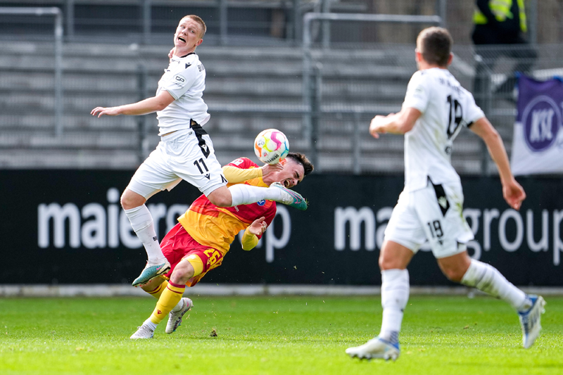 Philipp Ochs mit akrobatischer Einlage im Zweikampf mit KSC-Spieler Paul Nebel – rechts Bashkim Ajdini