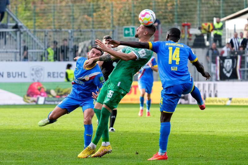 Sandhausens Janik Bachmann kommt zwischen den beiden Braunschweigern Robin Krauße (li.) und Anthony Ujah (re.) zum Kopfball