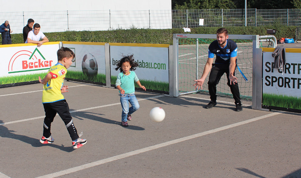 Björn von der TSG beim Fußballspielen mit Kindern auf dem Messeparkplatz