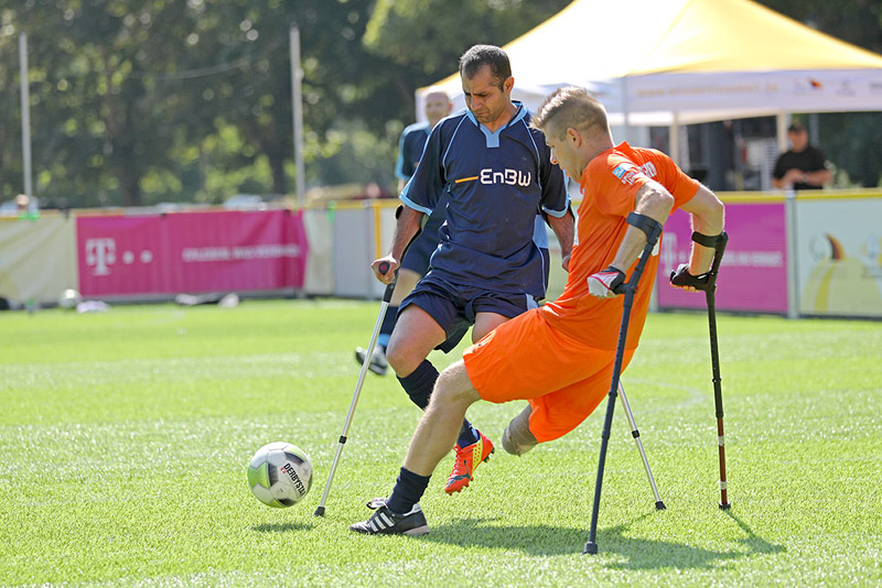 Anpfiff Hoffenheims Christian Heintz (oranges Trikot) und Braunschweigs Hussein Hamas stellen dem Publikum bei einem Stadtspieltag des Blindenfußballs ihre Sportart vor.