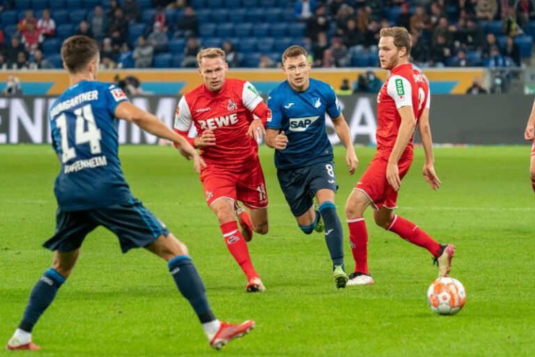 Geiger, der gerade seinen Vertrag um vier Jahre verlängert hat, setzt sich gegen zwei Kölner Gegenspieler durch - links in der Beobachterrolle Baumgartner
